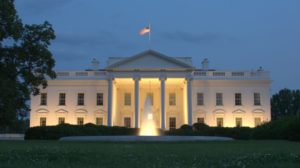 Front shot of the White House lit up at dusk.